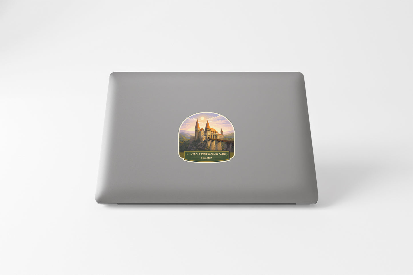 a sticker with a castle on it, placed on the back of a laptop.