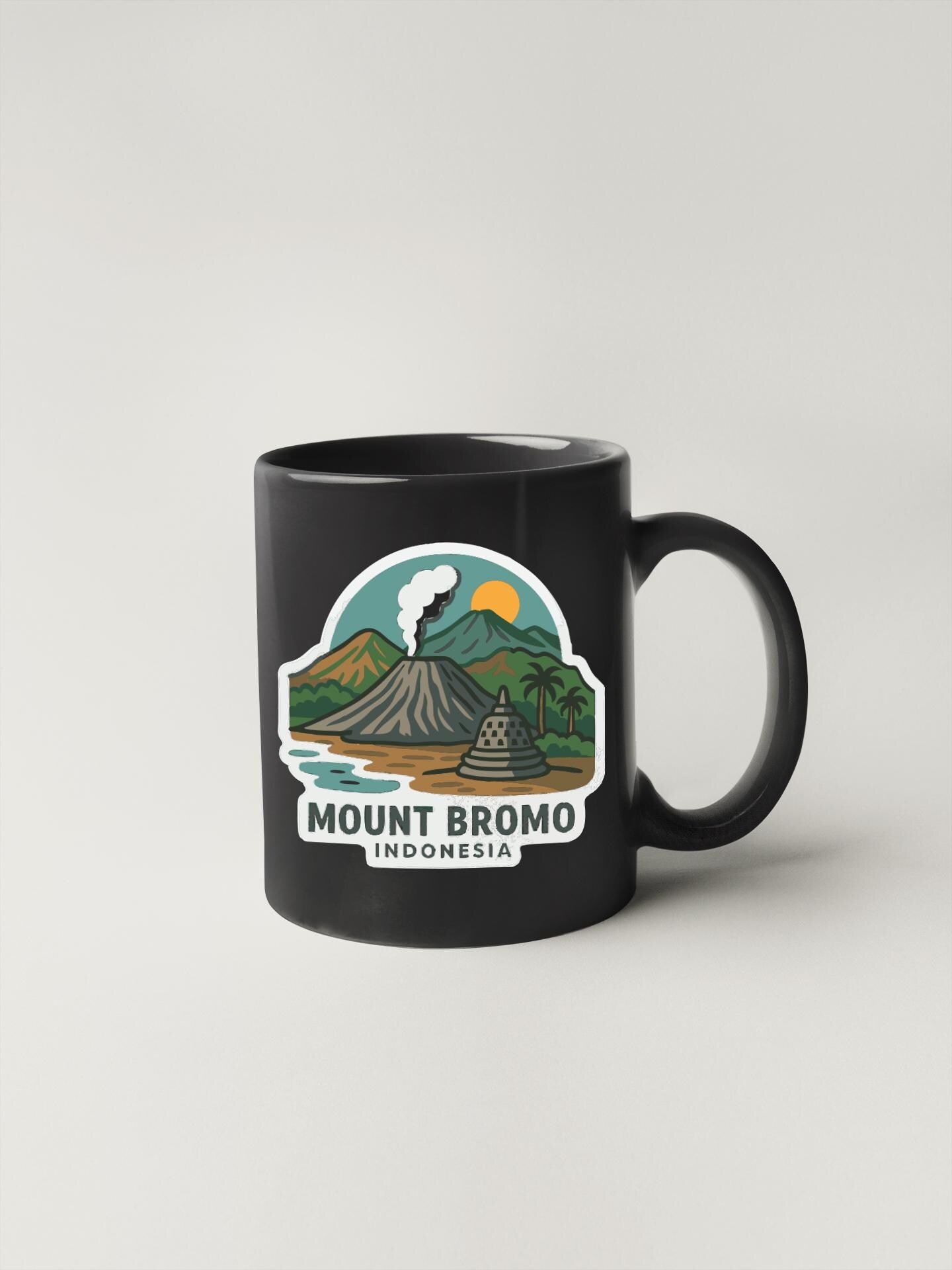 A black coffee mug with a graphic design depicting Mount Bromo, a famous landmark in Indonesia.