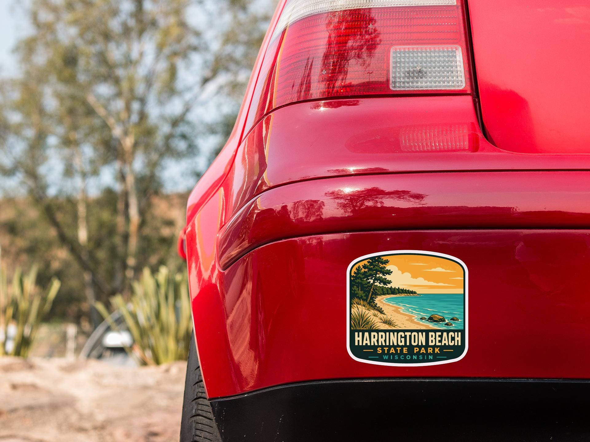 the rear end of a red car with a sticker on the back window that says "Harrington Beach State Park".