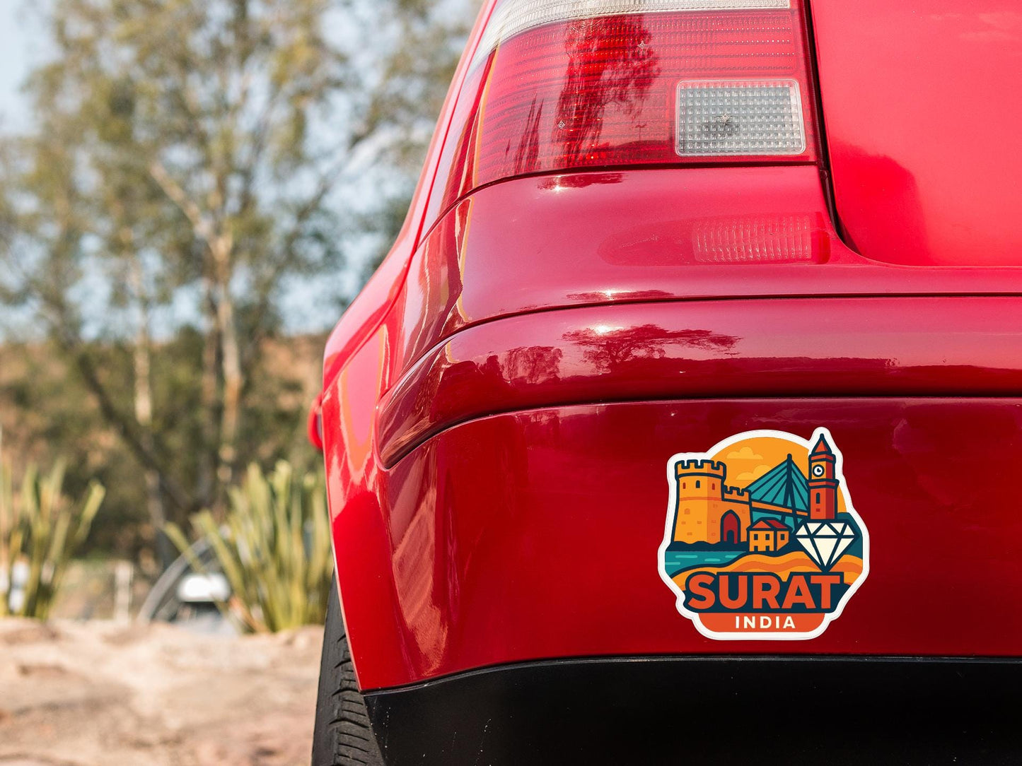 the rear end of a red car with a sticker on the back window that says "SURAT INIA".