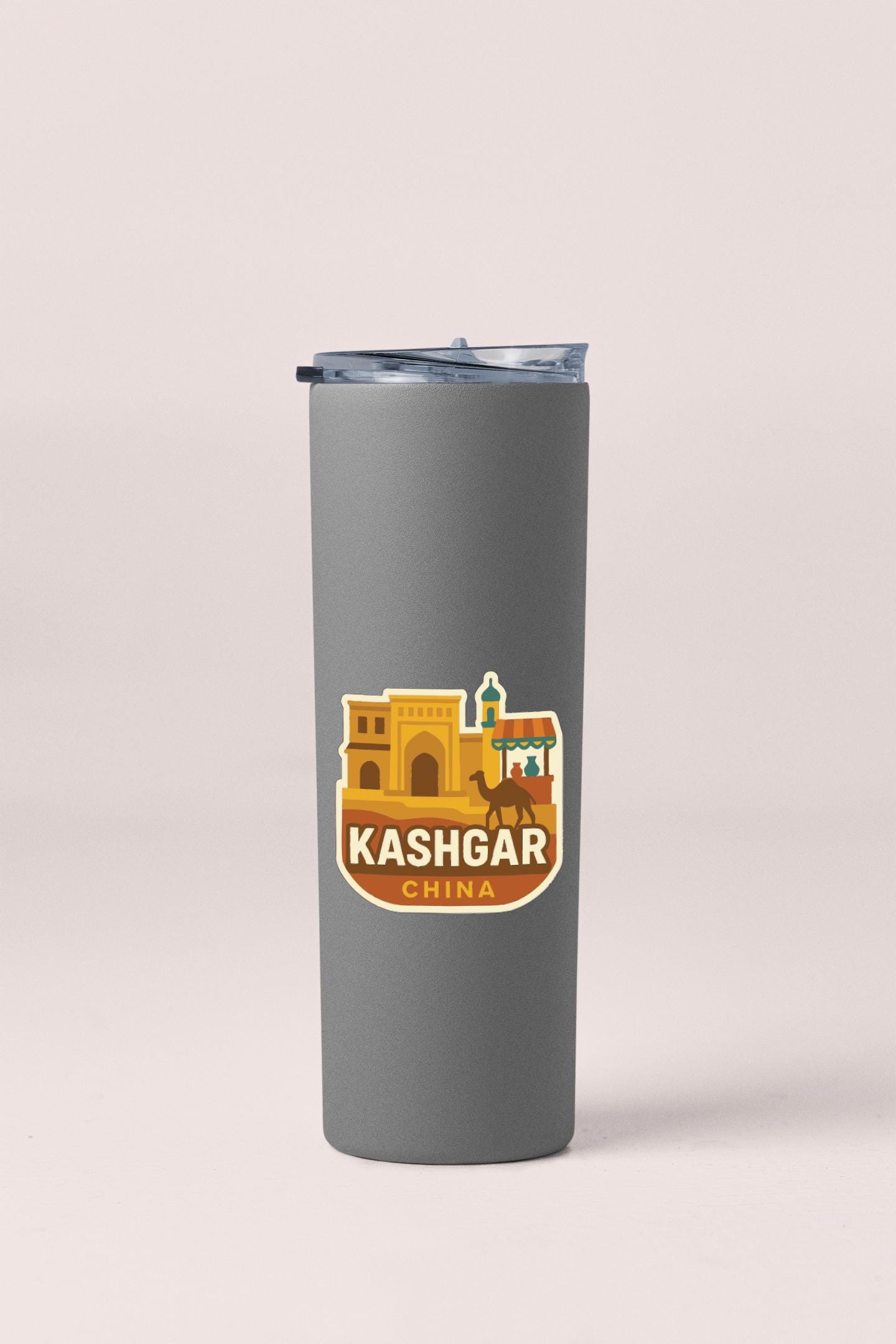 A gray insulated tumbler with a sticker depicting the city of Kashgar, China.
