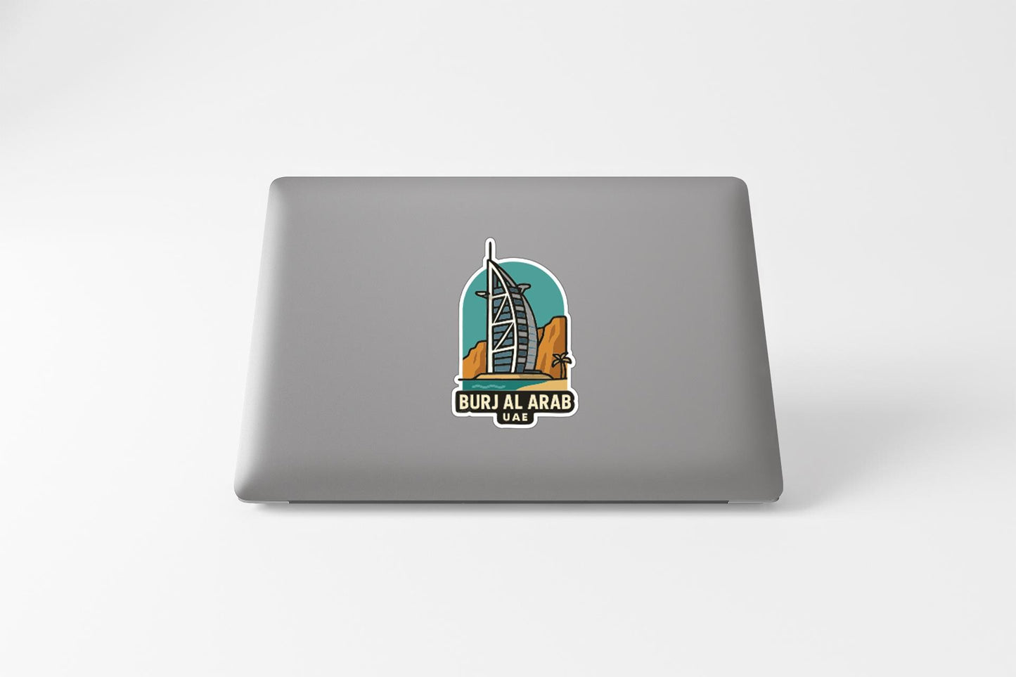 a sticker with an illustration of a building, specifically the Burj Al Arab hotel, on a laptop.