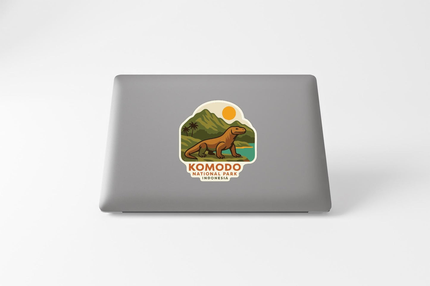 a sticker with a cartoon illustration of a Komodo dragon on a laptop.