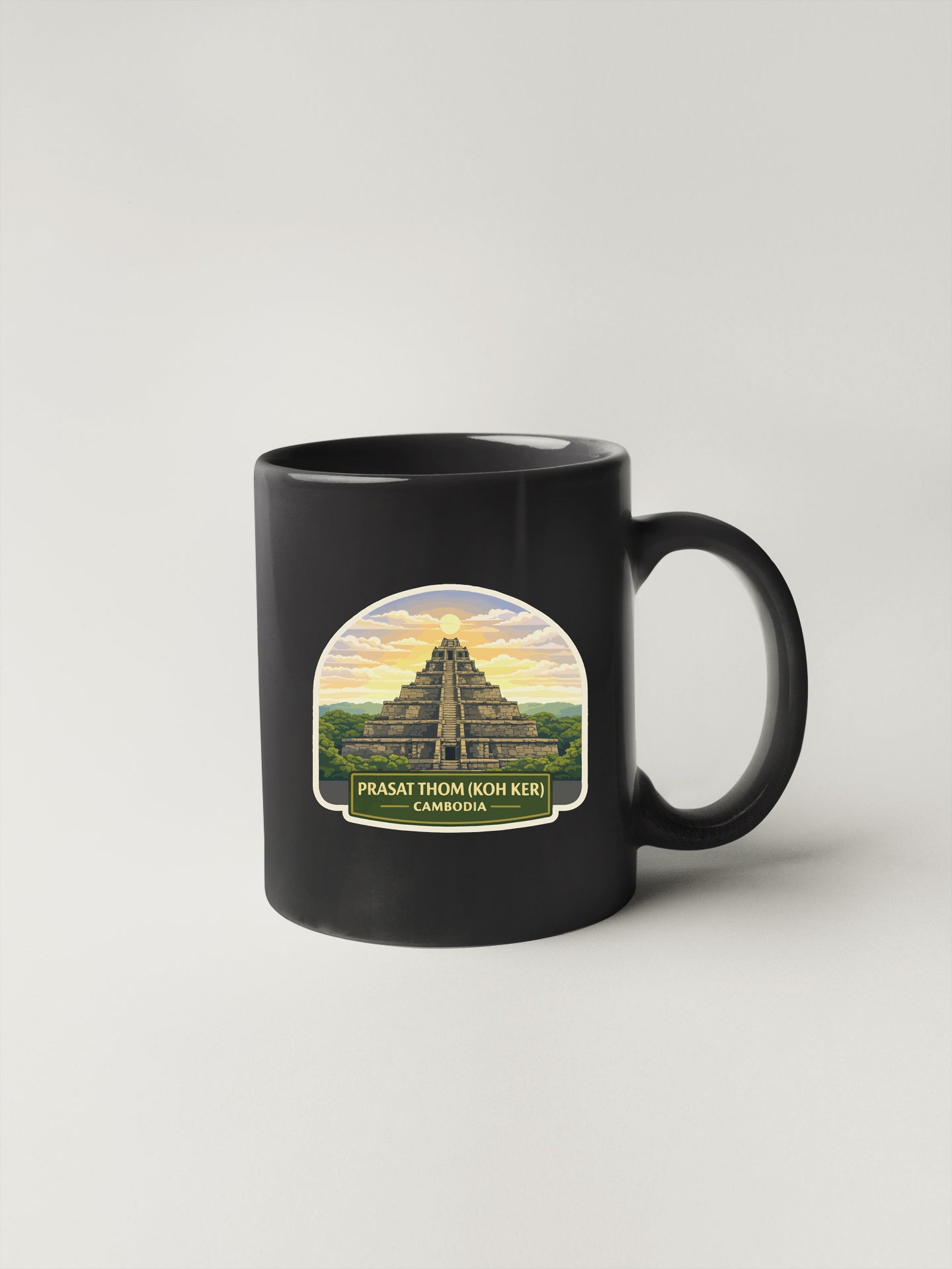 A black coffee mug with a graphic design depicting the Prasat Thom Ihok Ker temple in Cambodia.