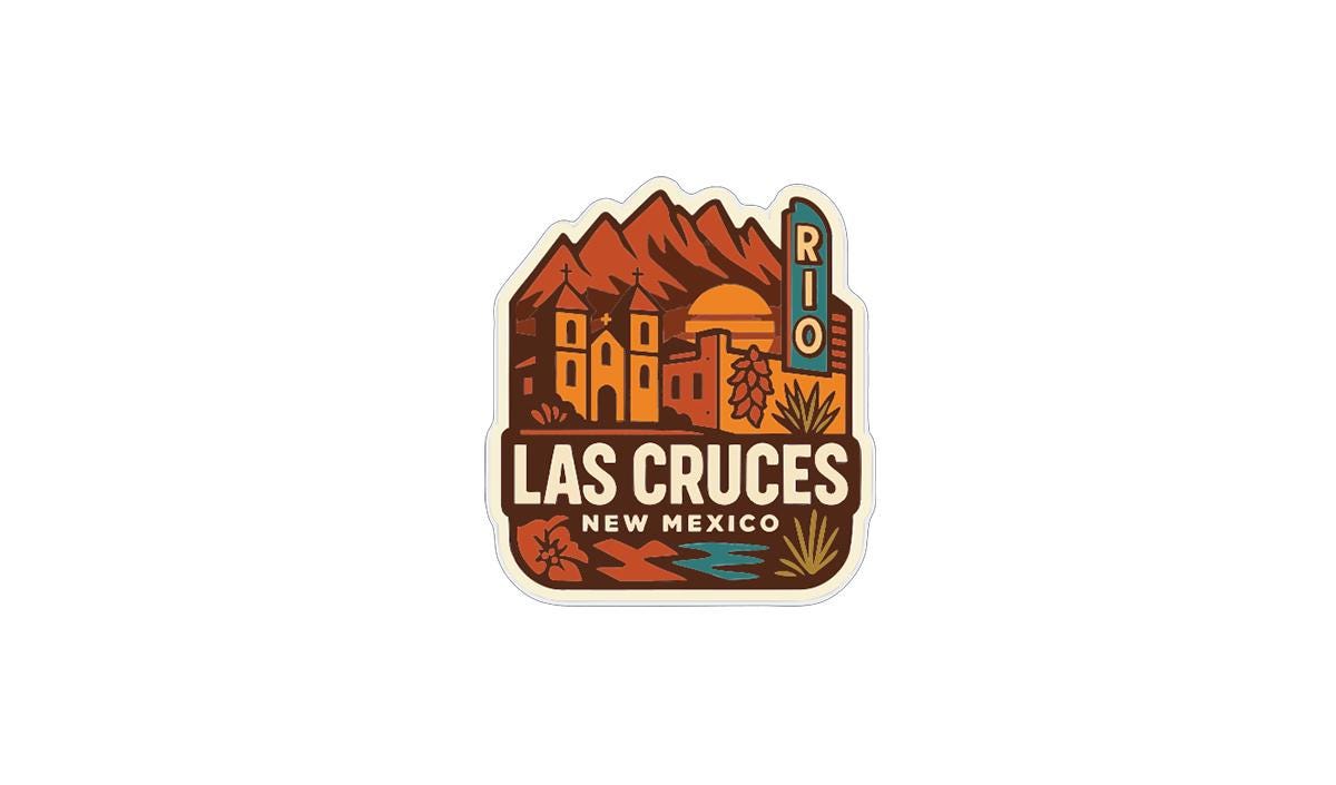 A sticker or logo featuring the city of Las Cruces, New Mexico, with a mountain range and buildings in the background.