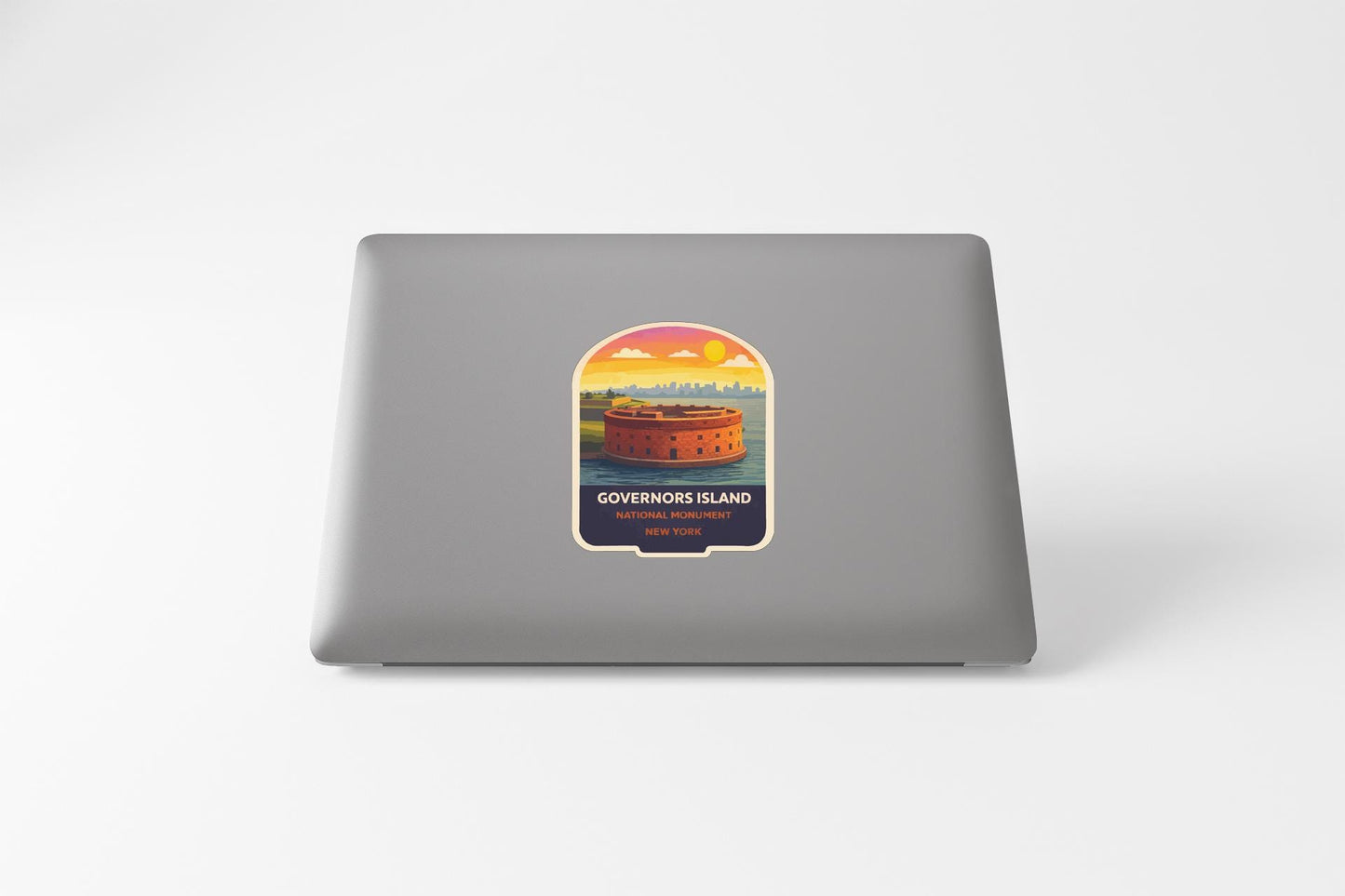 A sticker on the back of a laptop, depicting a castle or fortification with a sunset in the background.
