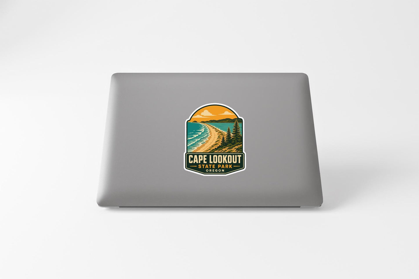 a sticker on a laptop that displays a scenic beach landscape with mountains in the background.