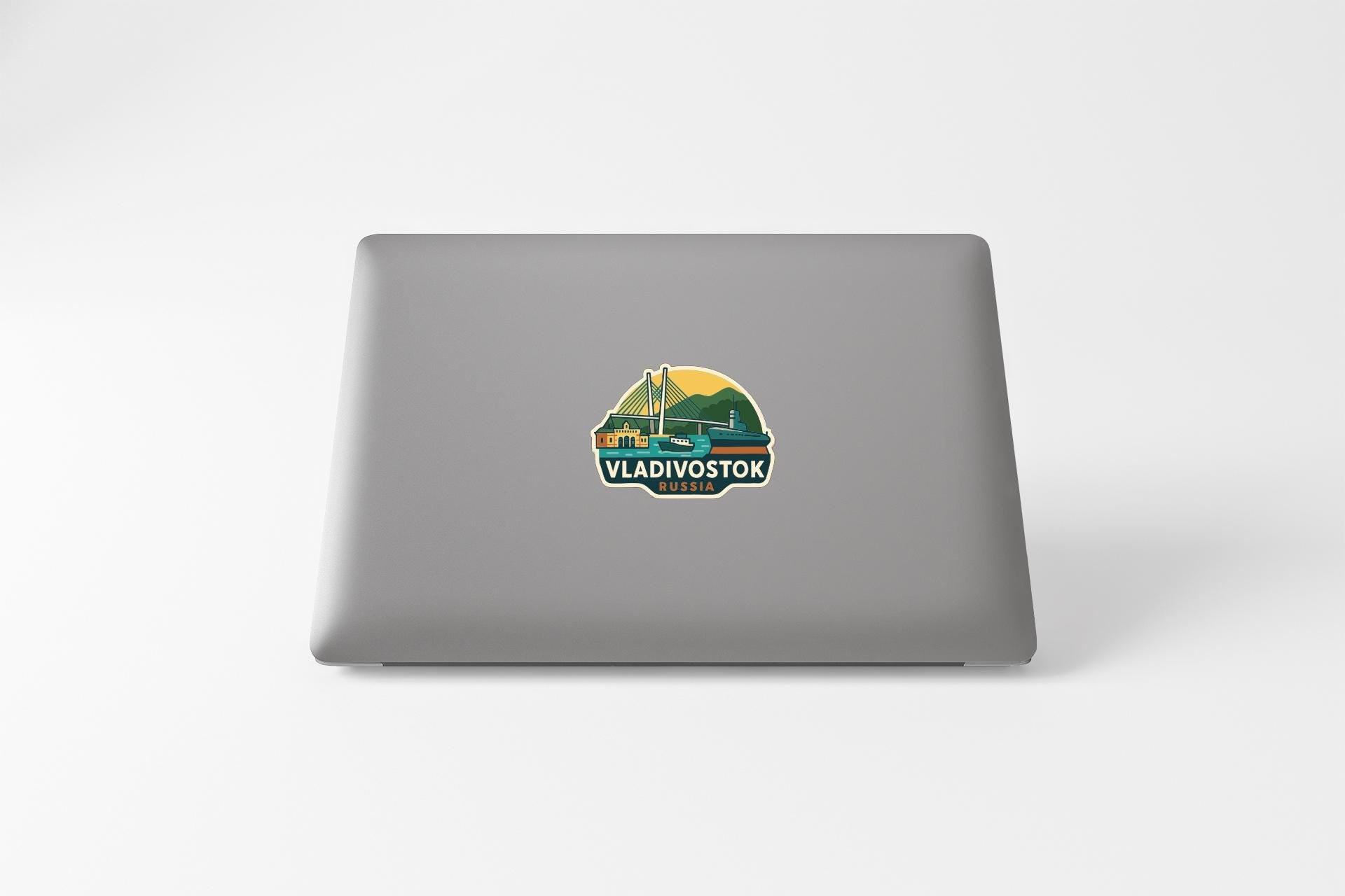 a sticker with a graphic of a boat and the text "VLADIVOSTOK" on the back of a laptop.
