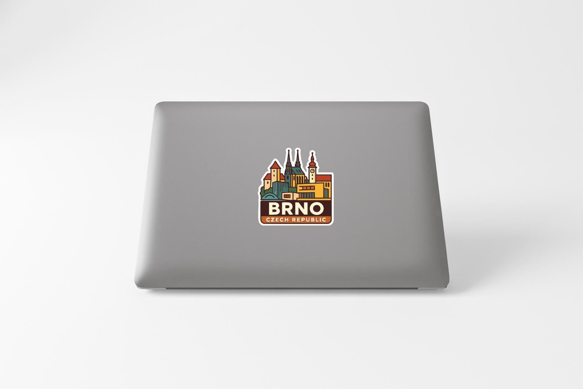 a sticker of a cityscape on the back of a laptop.