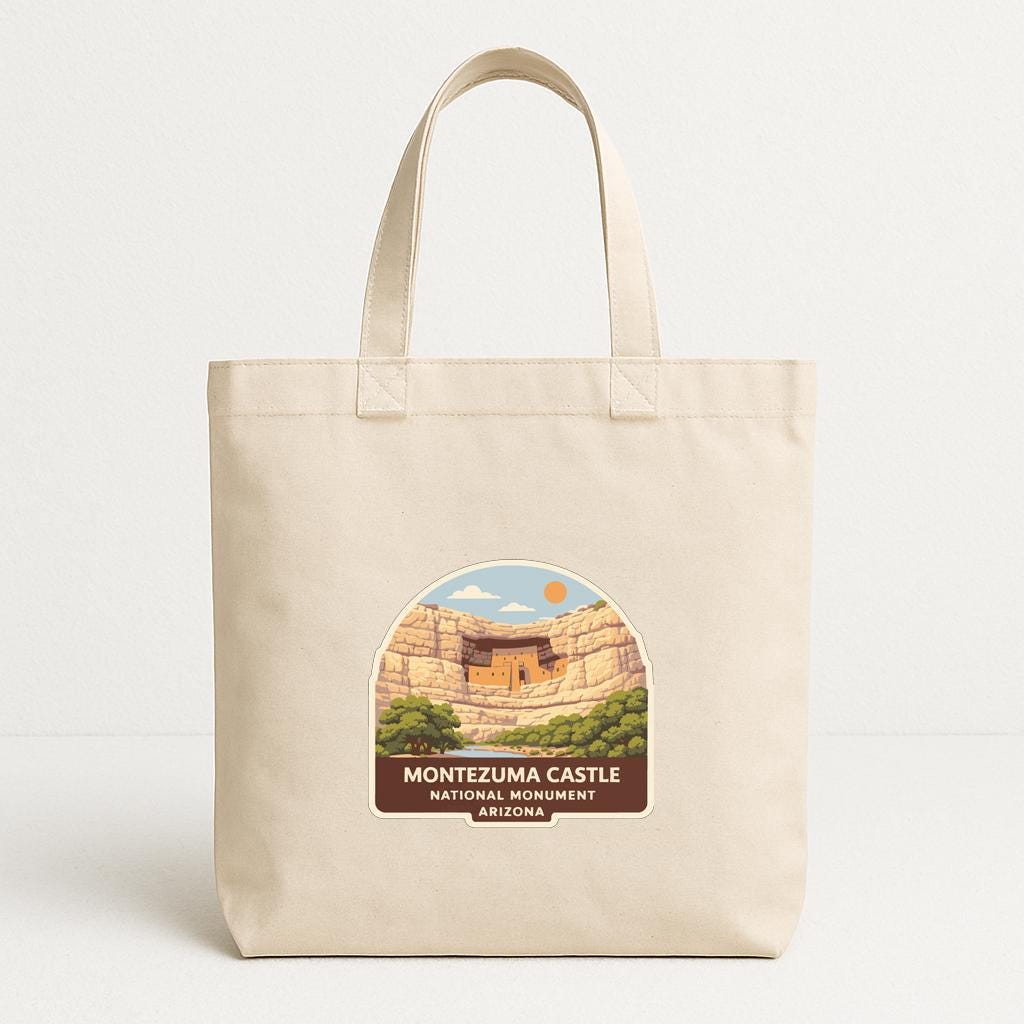 A beige tote bag with a label that features an illustration of the Montezuma Castle in Arizona.