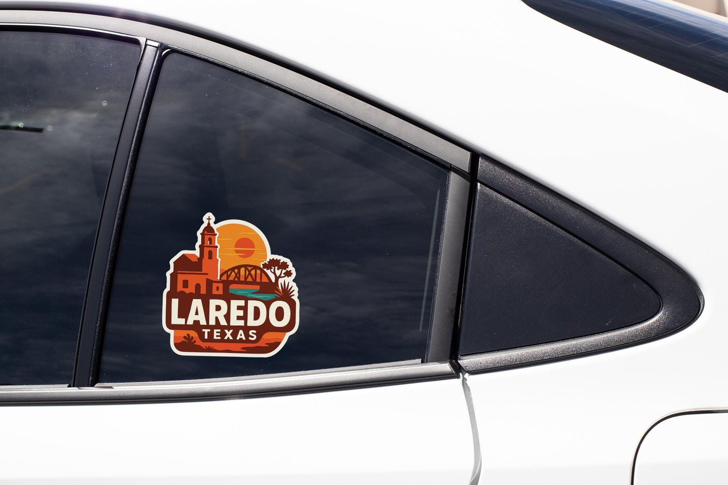 A sticker on the side of a car window that says "Laredo, Texas".