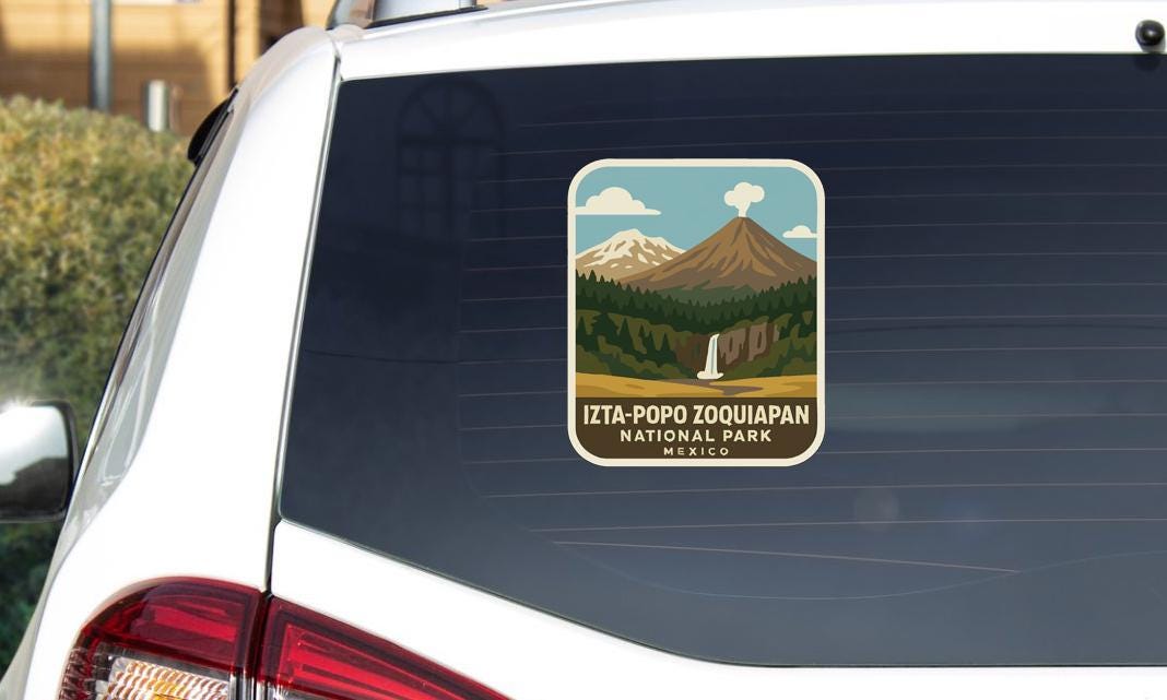 A sticker on the rear window of a car, depicting a scenic landscape with mountains, a waterfall, and a forest.