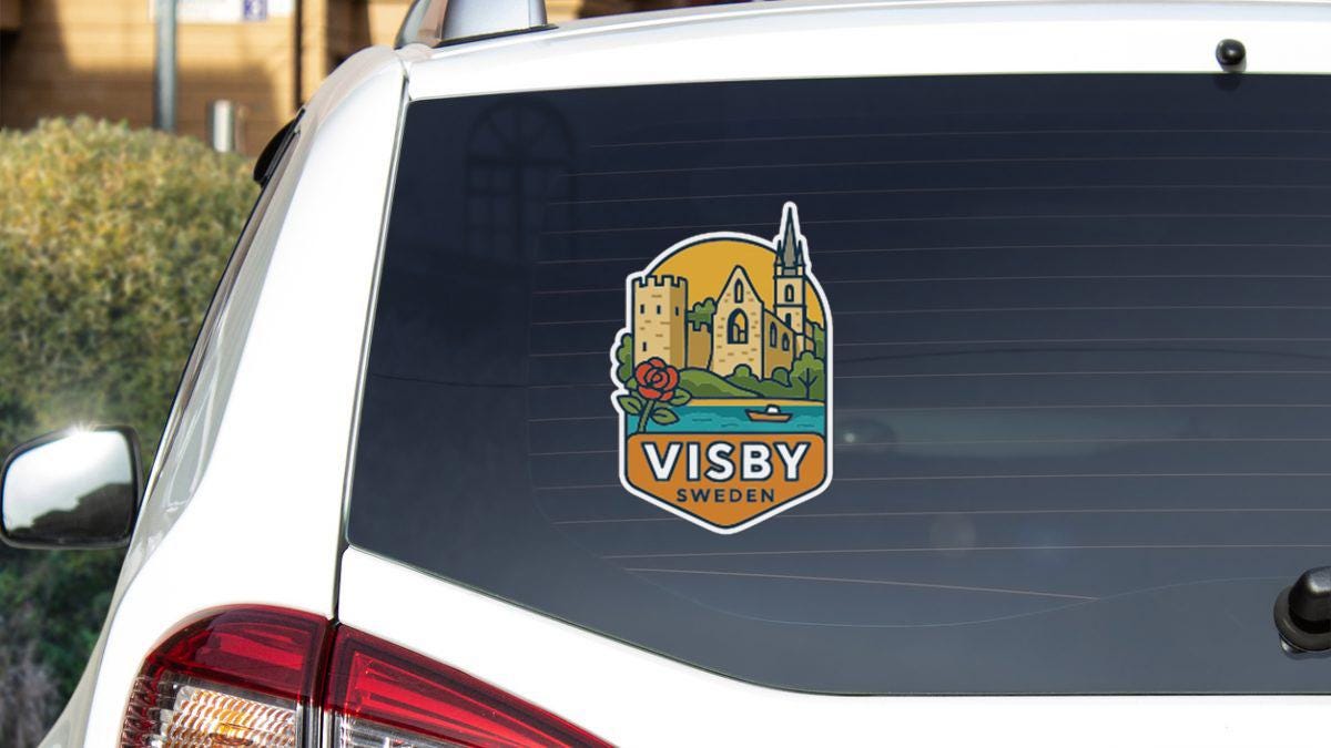 a sticker on the rear window of a car, featuring a castle and a rose, with the text "VISBY SWEDEN" printed on it.