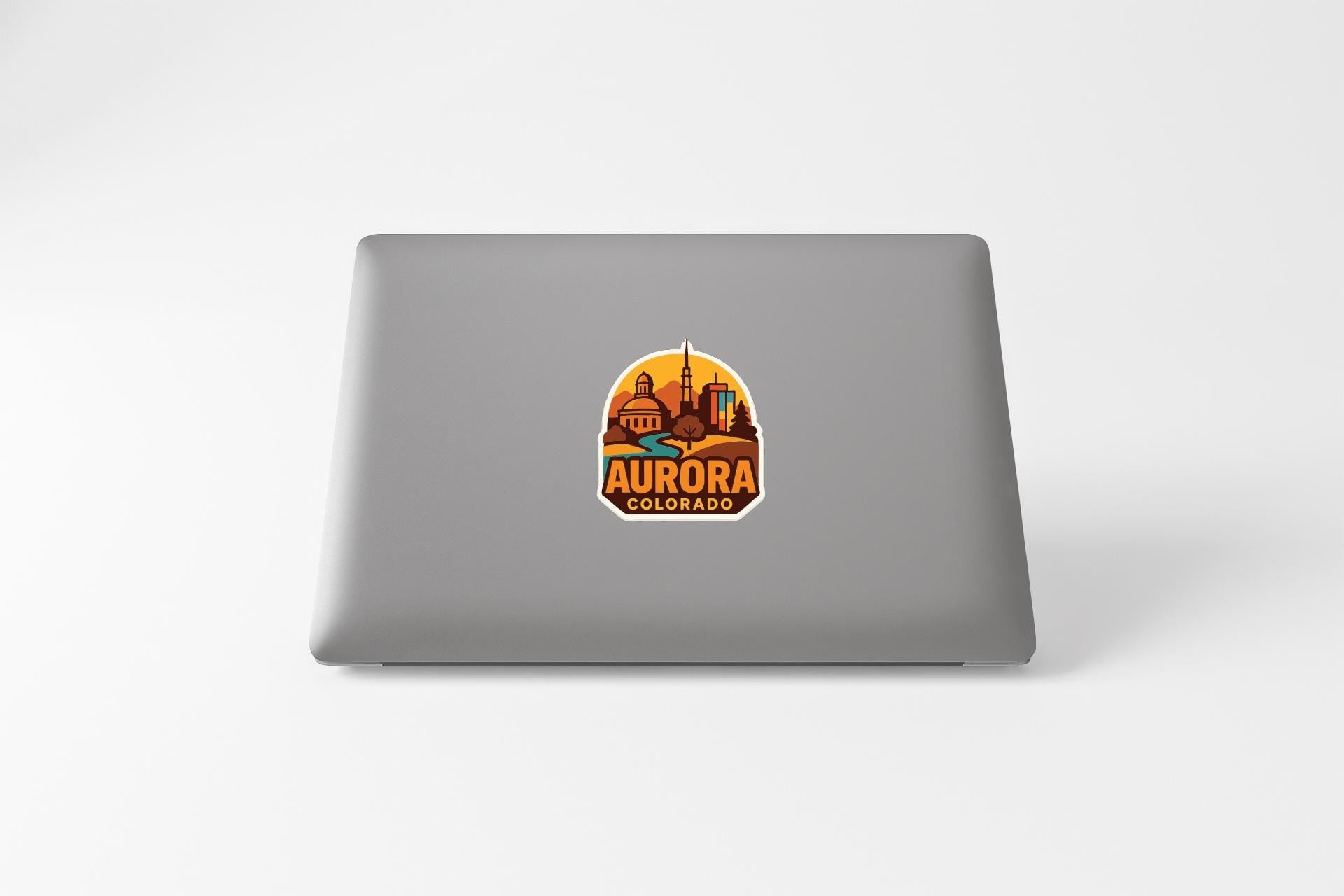 a sticker of Aurora, Colorado, on the back of a laptop.