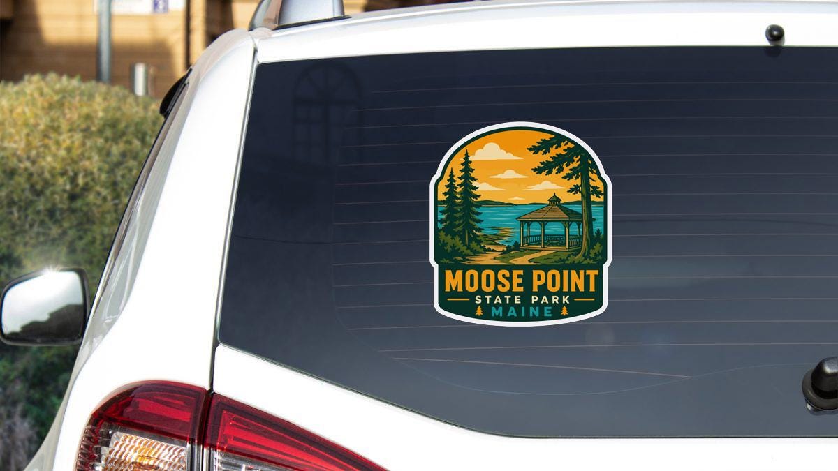A sticker on the rear window of a white vehicle, depicting a scenic landscape with a gazebo and pine trees, with the text " Moose Point State Park Maine" printed on it.