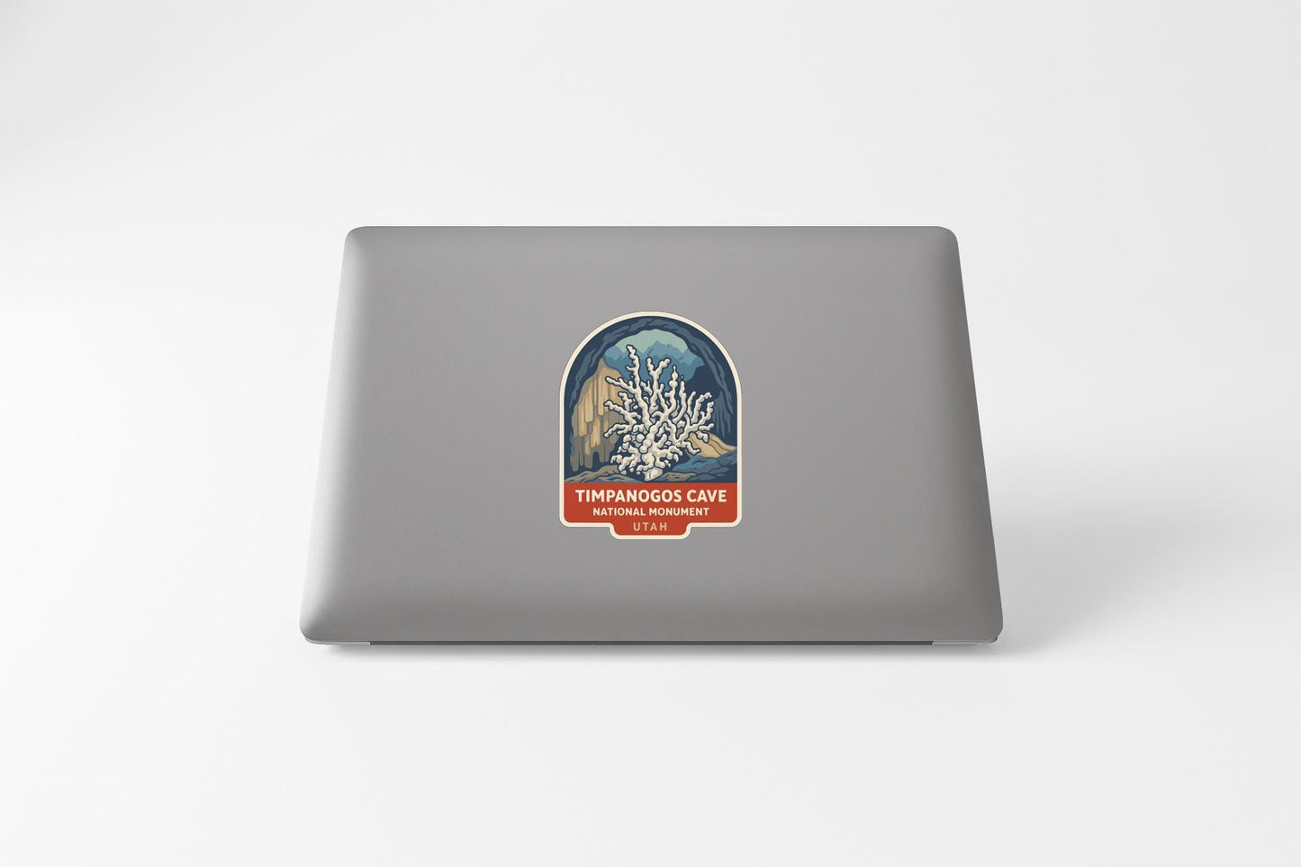a sticker on the back of a laptop, depicting a coral reef with the text "TIMPHANOOS CAVE NATURAL WONDERS ST. LOUIS" printed on it.