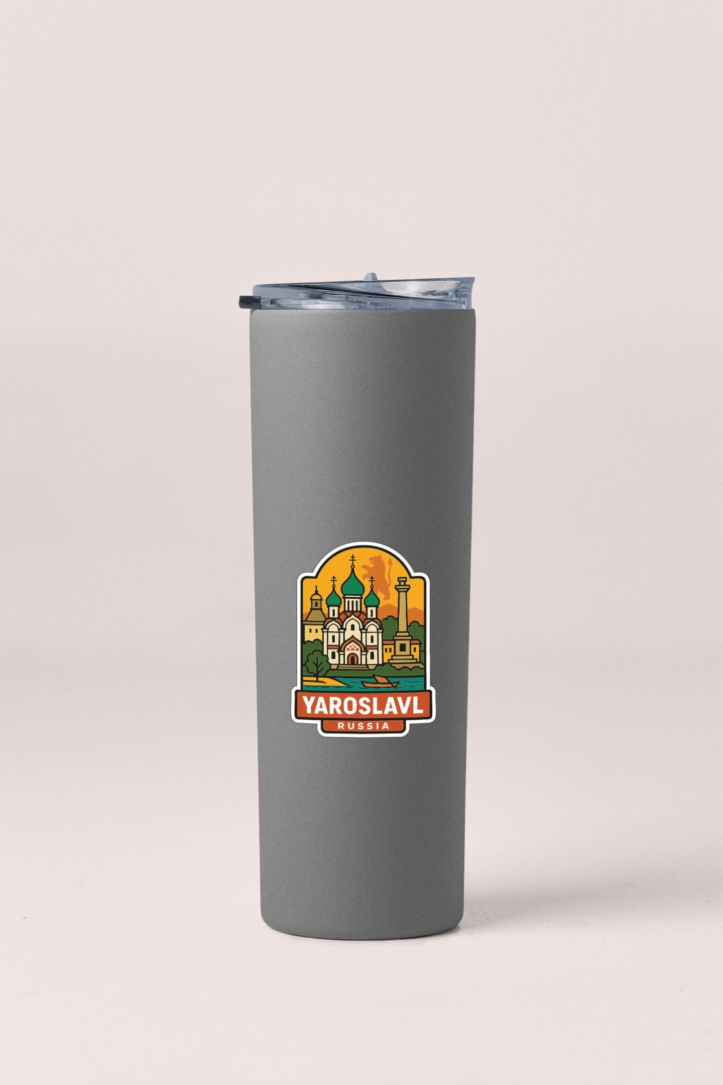 A gray insulated tumbler with a sticker depicting a cityscape and the text "YAROSLAV" and "RUSSIA" printed on it.