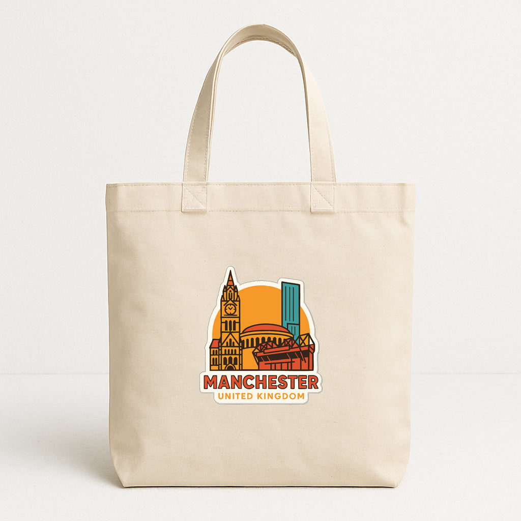 A beige tote bag with a printed design of the Manchester United football club and the text "MANCHESTER UNITED KINGDOM" printed on it.