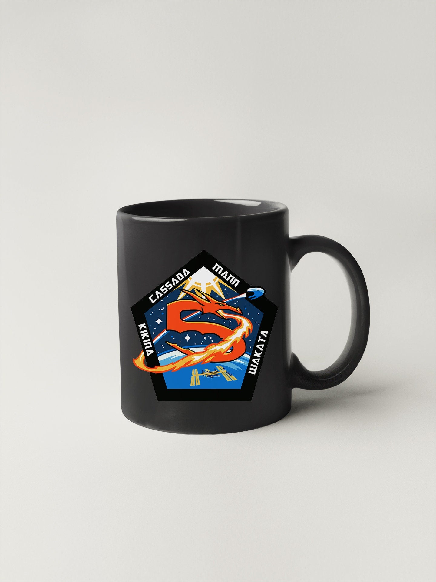a black mug with a picture of a dragon on it