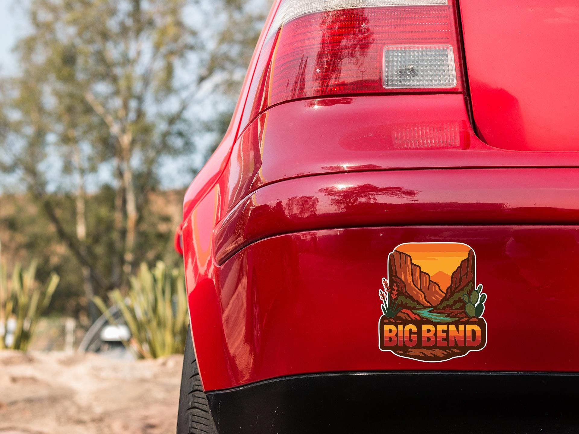 the rear end of a red car with a sticker on the trunk that says "BIG BEND".