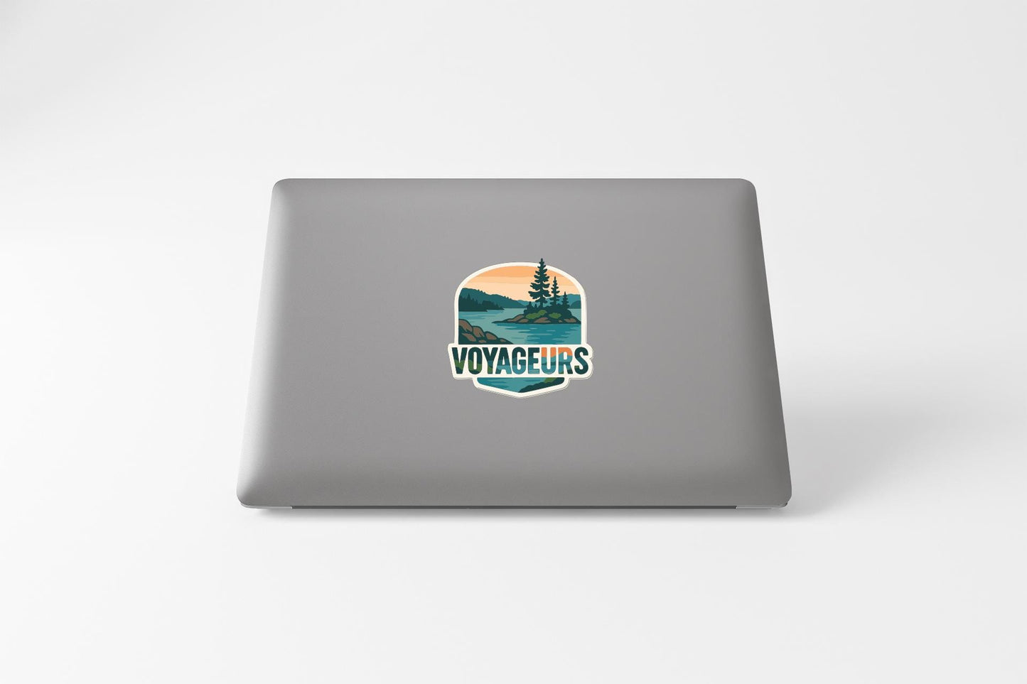 a sticker on the back of a laptop that says "VOYAGEURS".