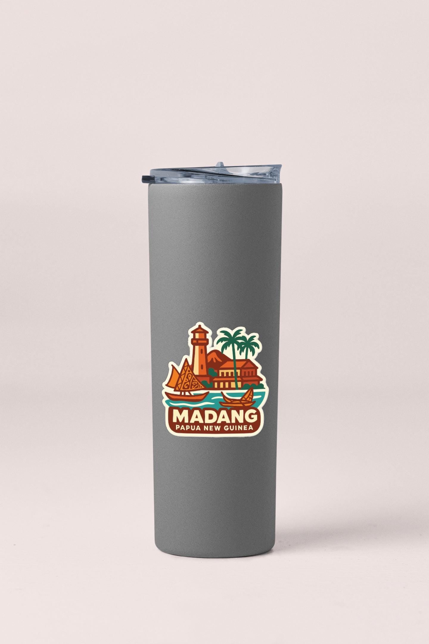 A gray insulated tumbler with a sticker depicting a tropical island and a lighthouse.