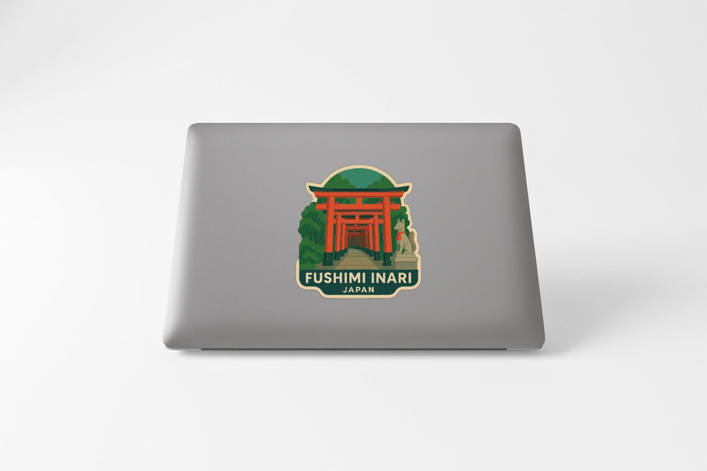 A sticker depicting the Fushimi Inari, a famous Japanese torii gate, on the back of a laptop.