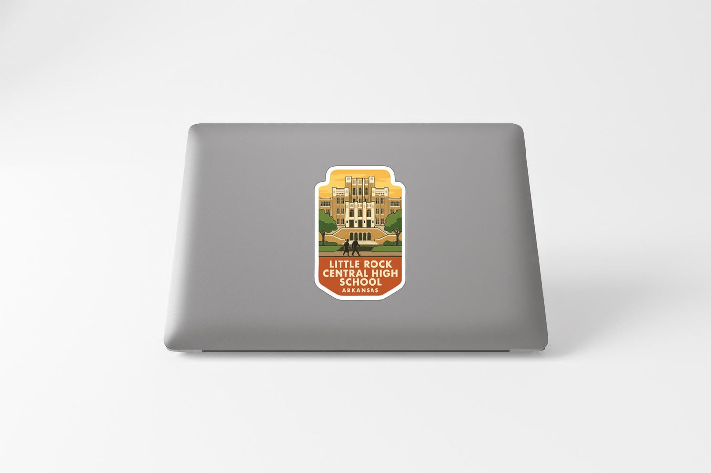 A sticker on the back of a laptop, depicting a school building.