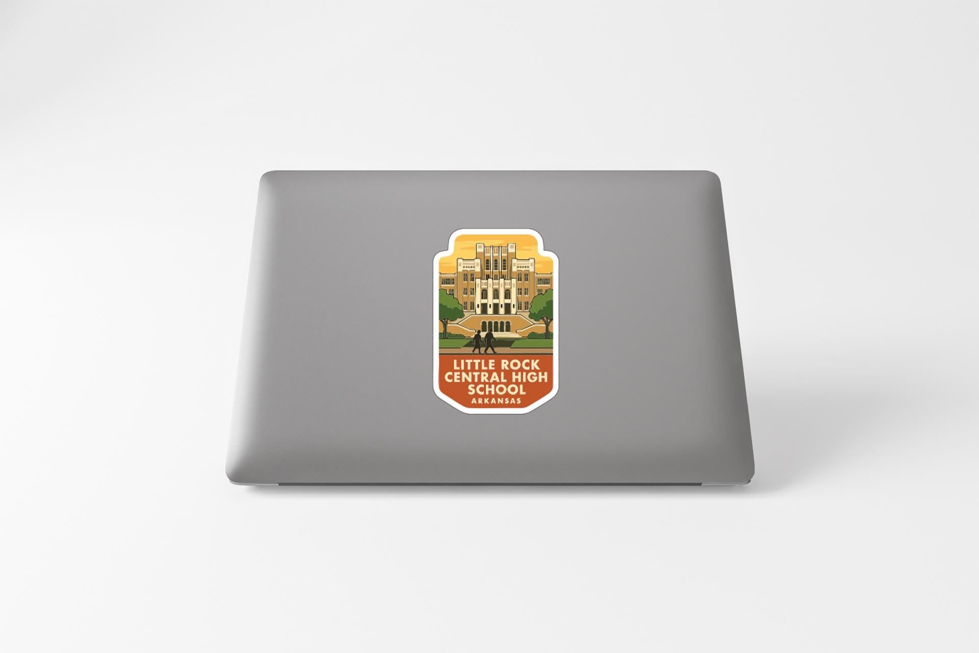 A sticker on the back of a laptop, depicting a school building.
