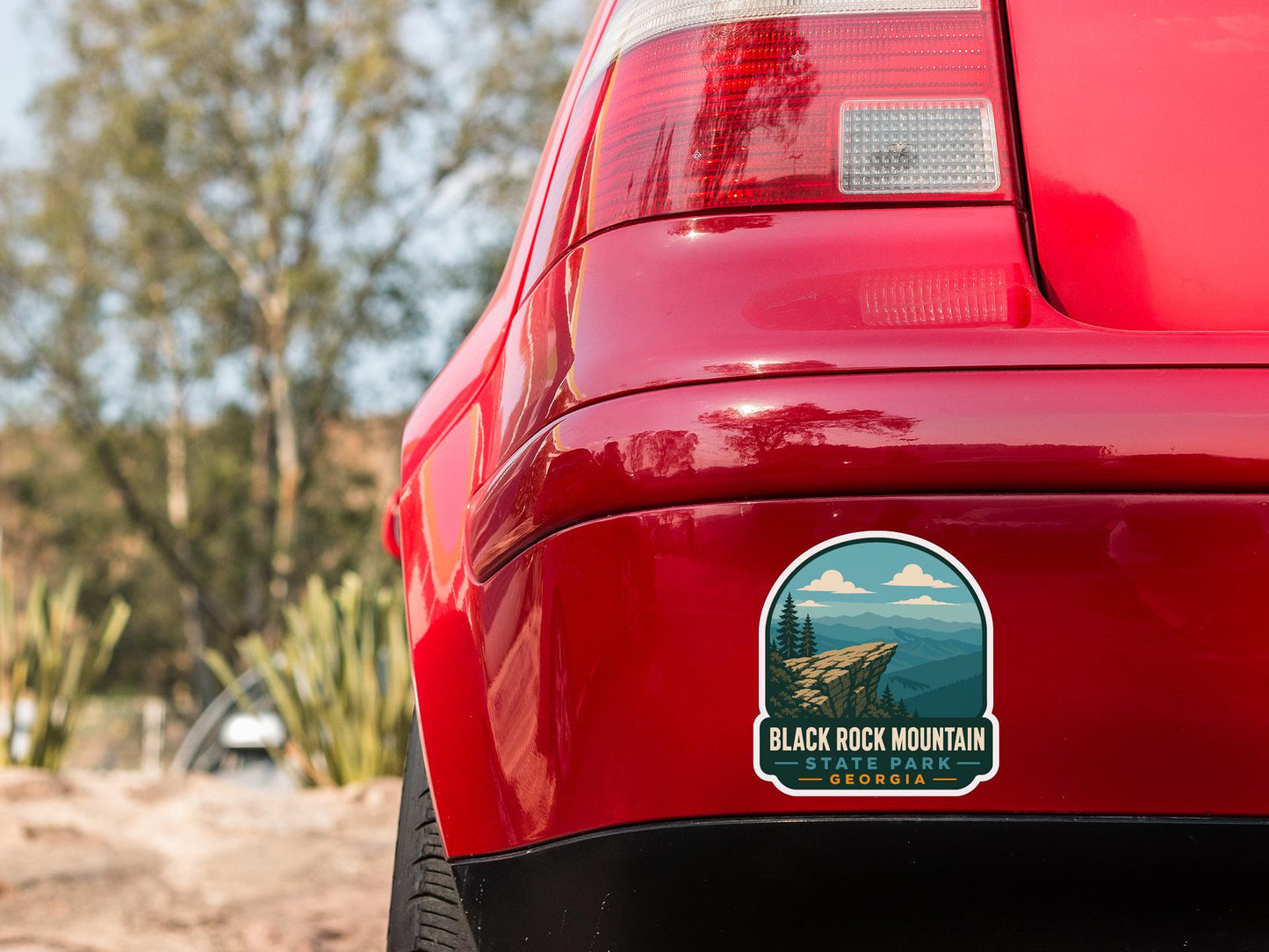 the rear end of a red car with a sticker on the back window that says "Black Rock Mountain, Georgia".