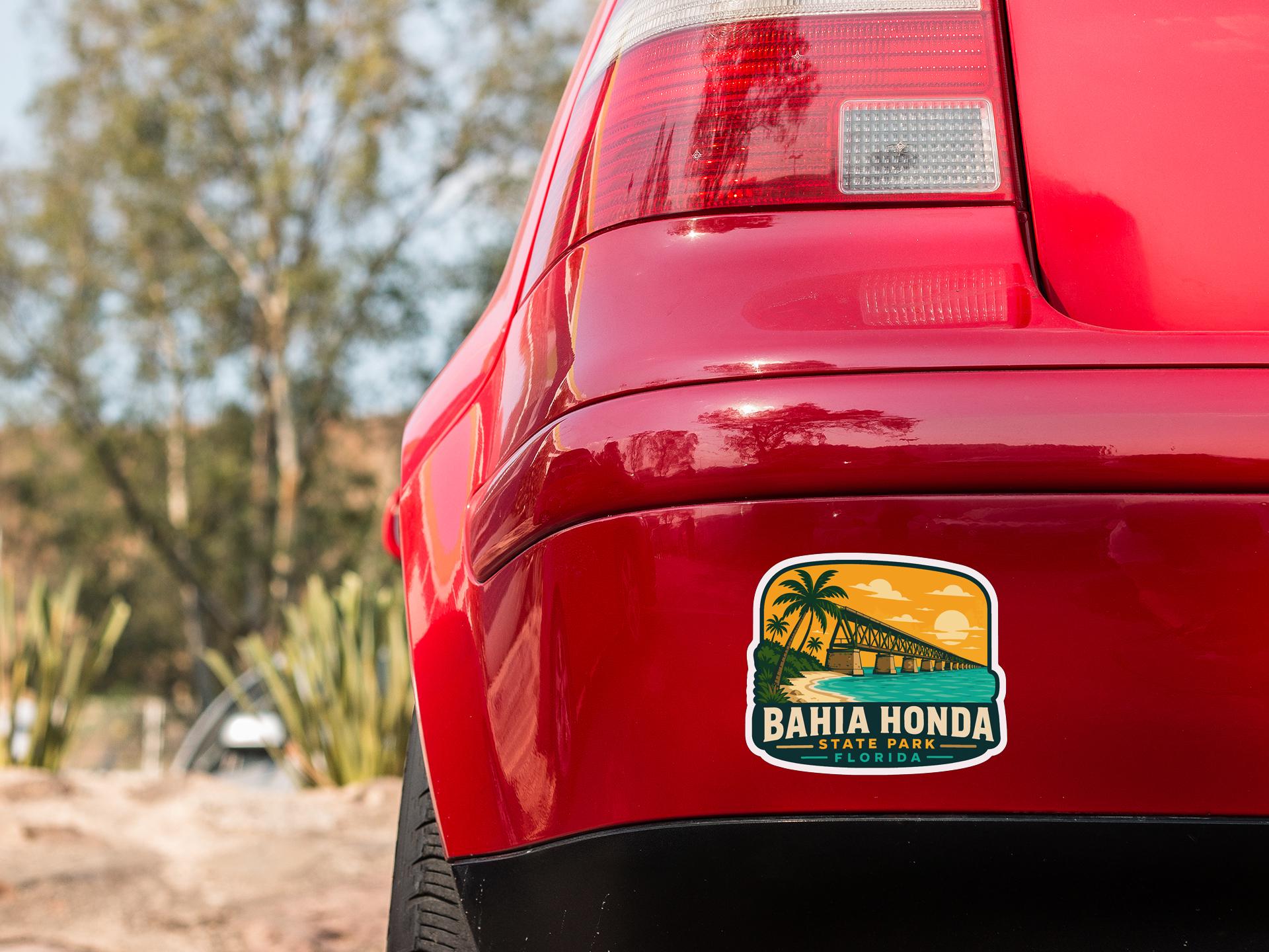 the rear end of a red car with a sticker on the trunk that says "BAHIA HONDA STATE PARK".