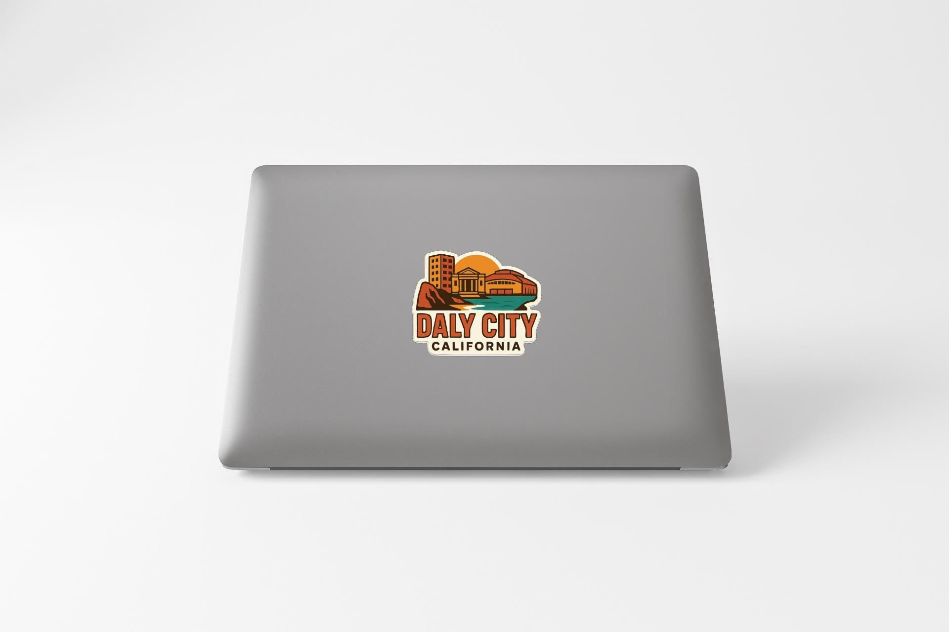 a sticker on the back of a laptop that says "Daly City, California".
