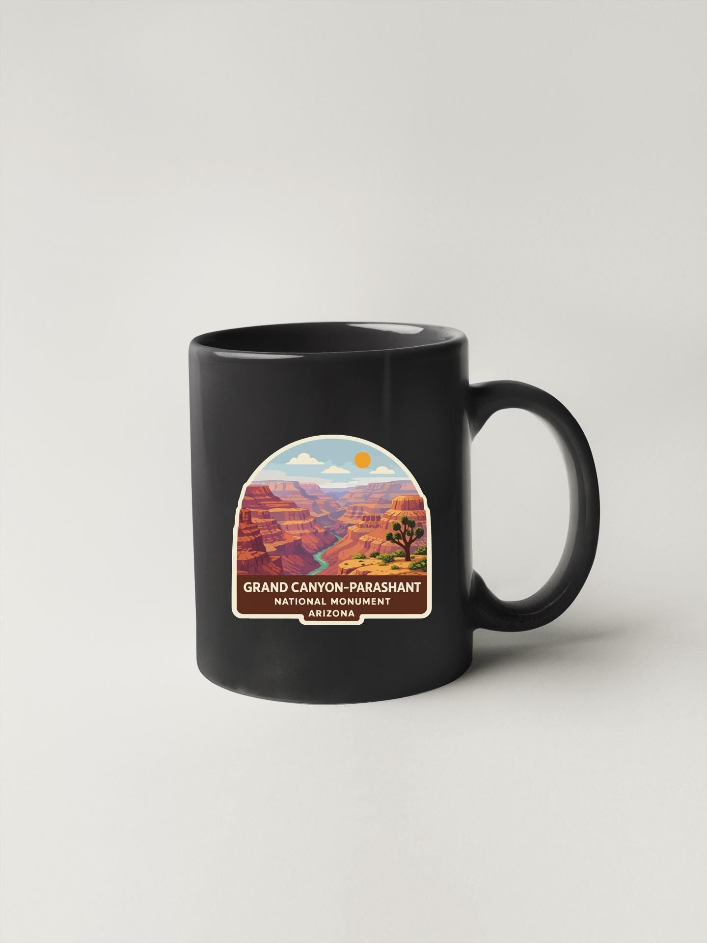 A black coffee mug with a graphic design depicting the Grand Canyon-Parashant National Monument in Arizona.