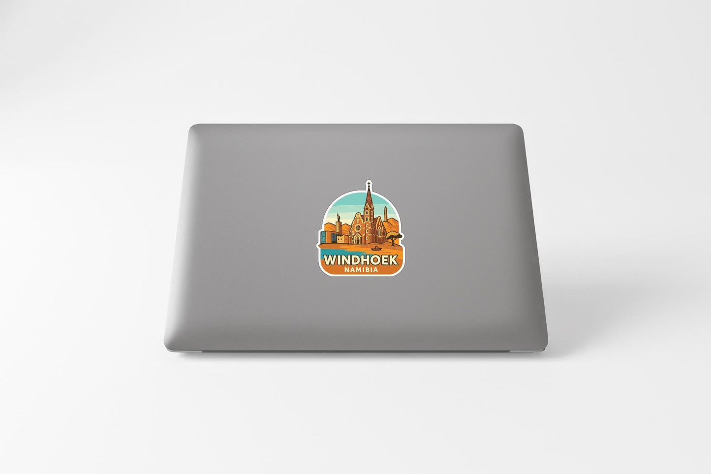 A sticker depicting the Windhoek cityscape on the back of a laptop computer.