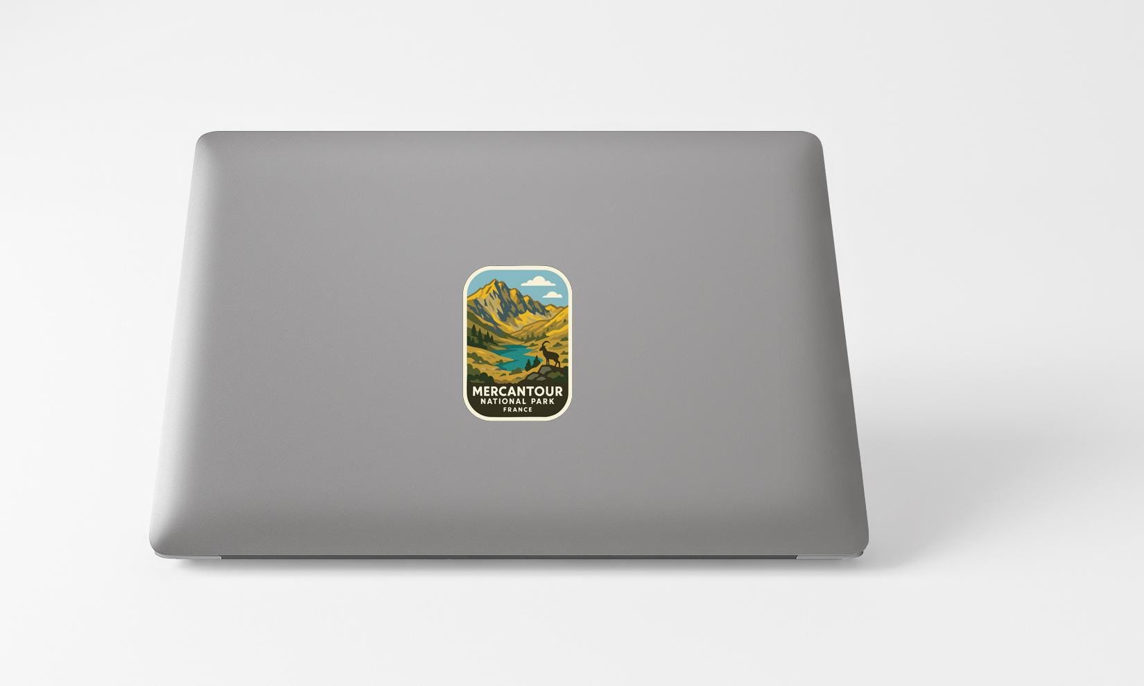 A sticker with a mountain landscape on a laptop.