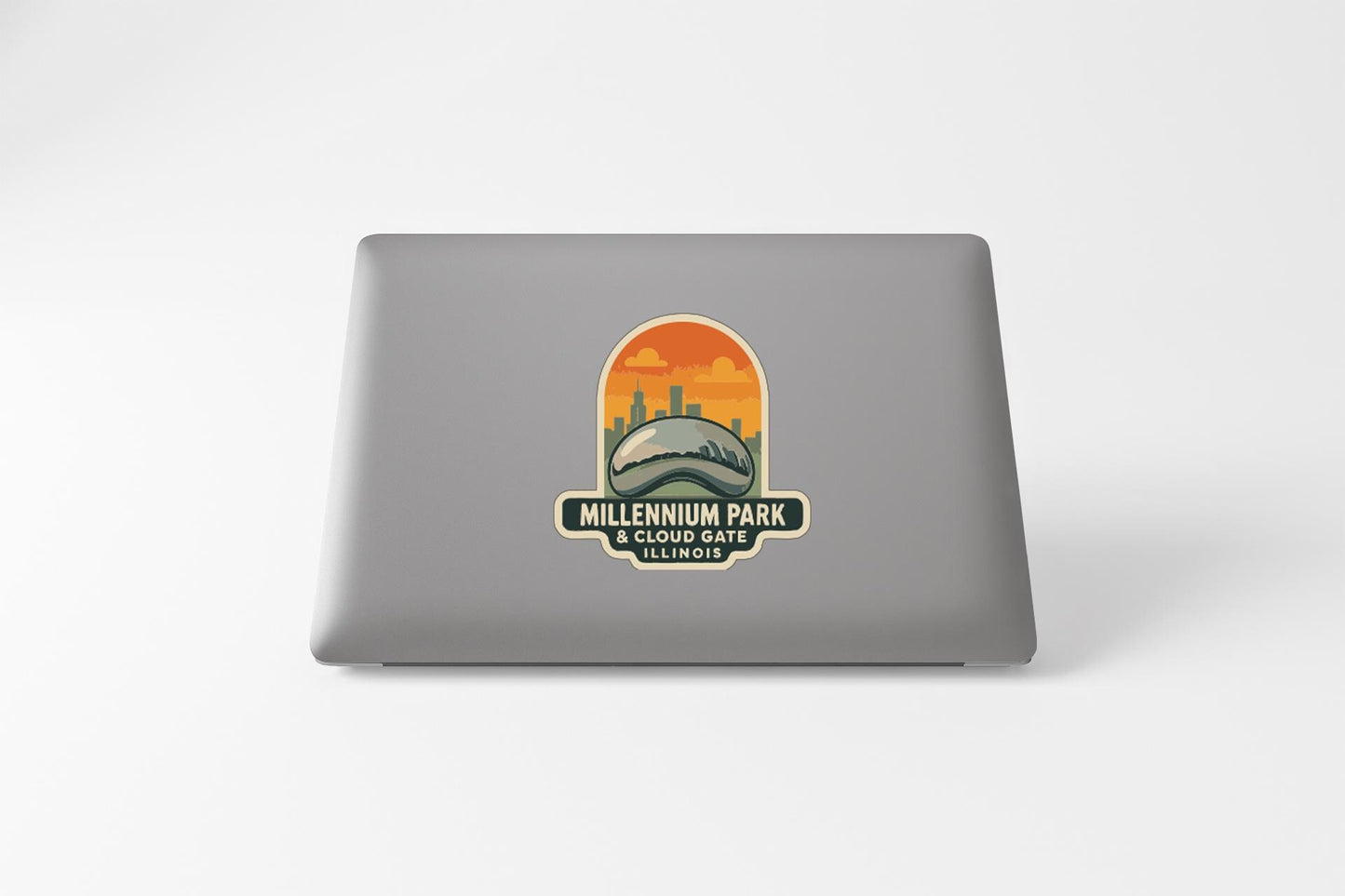a sticker on the back of a laptop, depicting a city skyline with a large stadium in the center.