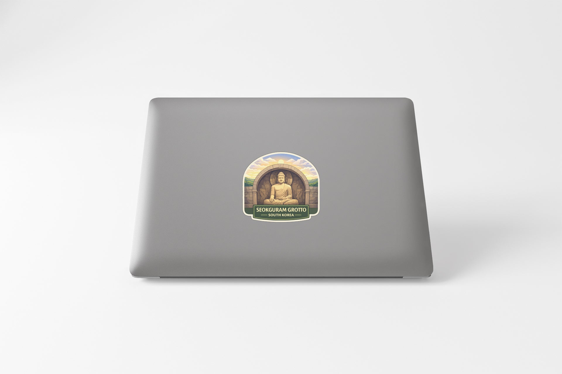 a sticker with a Buddha image on a laptop.