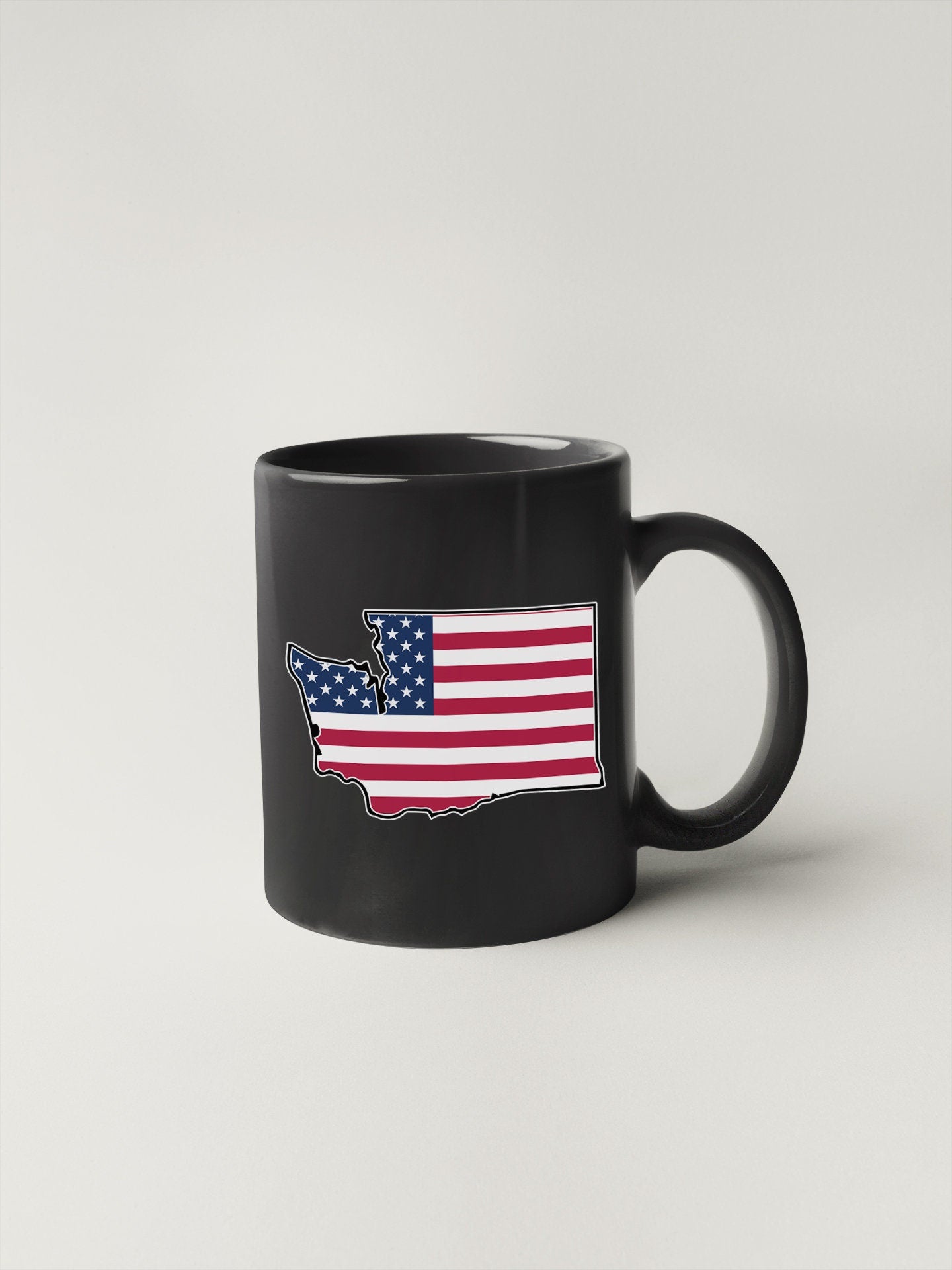 a black coffee mug with an american flag on it