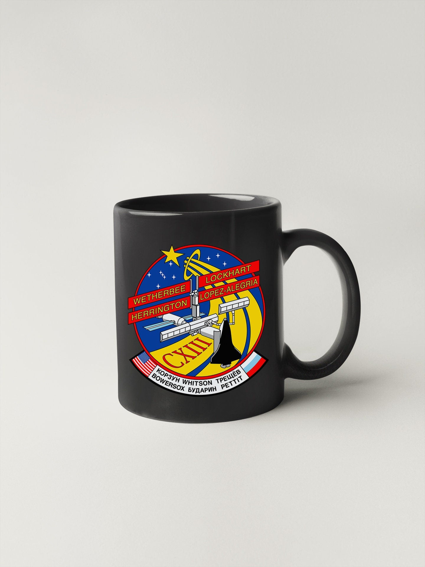 a black coffee mug with a nasa emblem on it