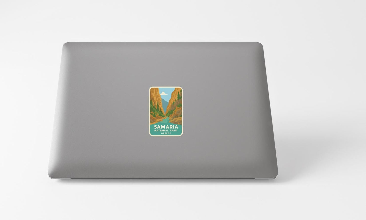 A sticker with a mountain landscape and the text "SAMARIA NATIONAL PARK" printed on a grey laptop.
