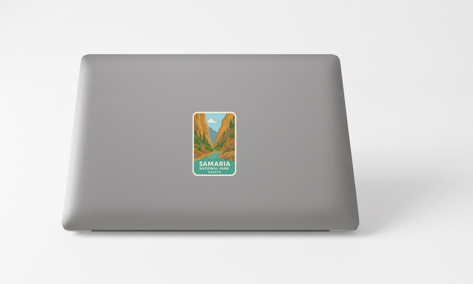 A sticker with a mountain landscape and the text "SAMARIA NATIONAL PARK" printed on a grey laptop.