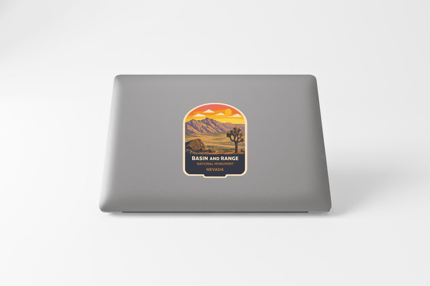 a sticker with a desert landscape and mountains on the back of a laptop.