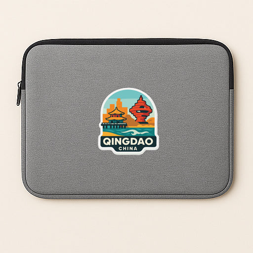 A gray laptop sleeve with a colorful sticker depicting the skyline of Qingdao, China.