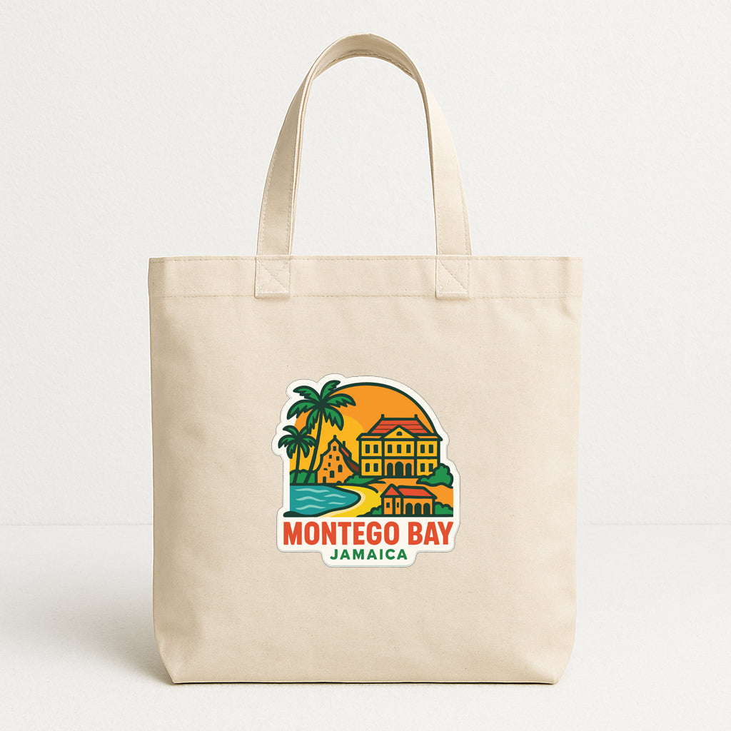 A beige tote bag with a colorful graphic depicting a tropical island and a building, along with the text "MONTEGO BAY JAMAICA".