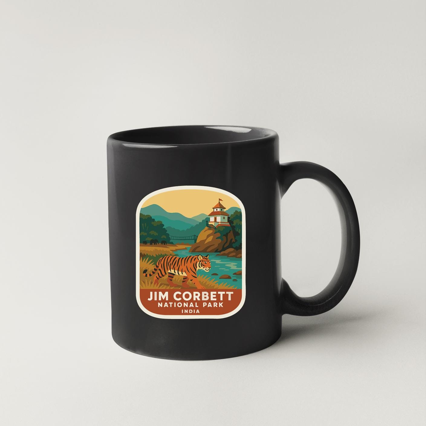 A black coffee mug with a label depicting a tiger and a lighthouse in a scenic landscape.