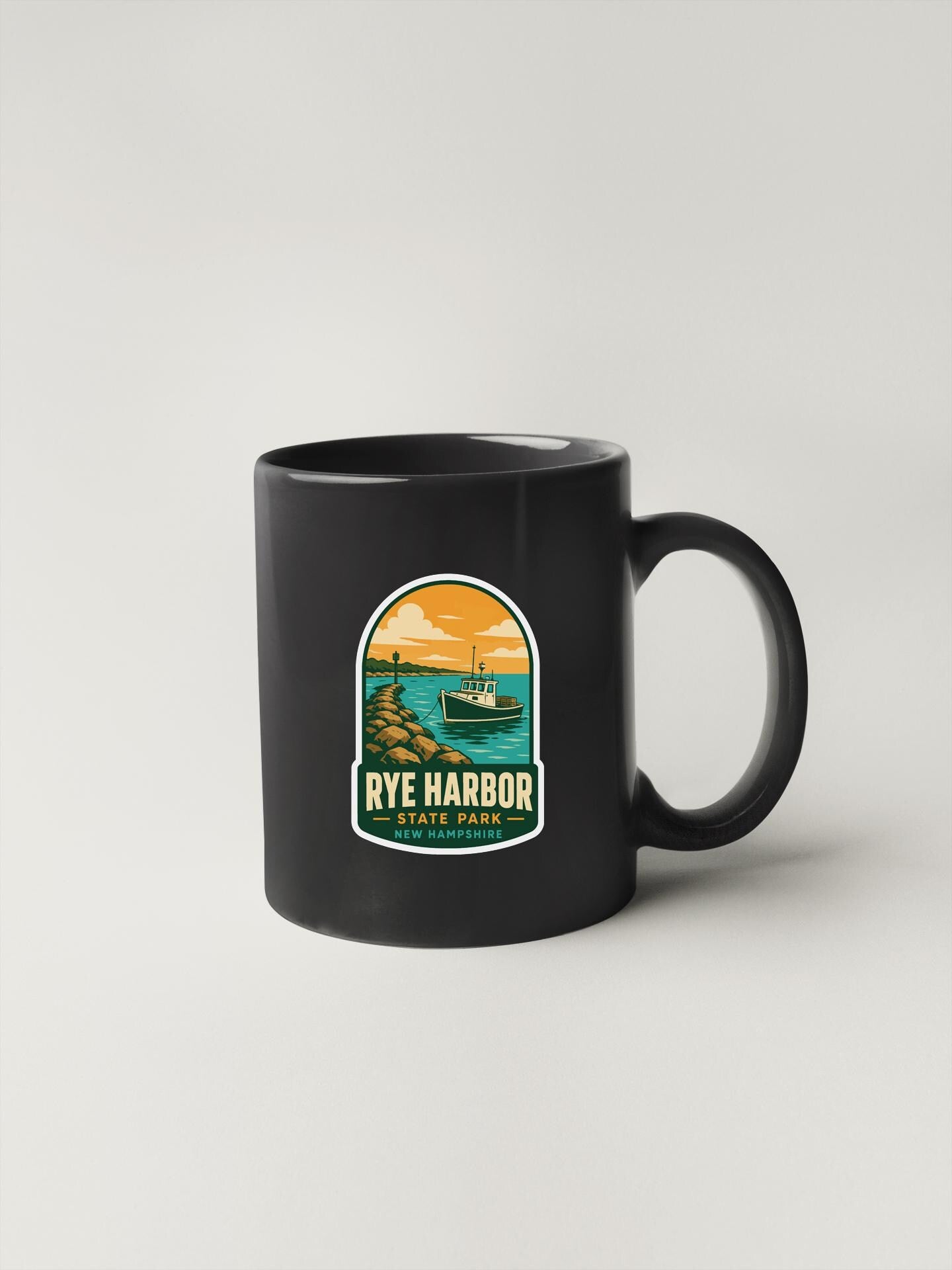 A black coffee mug with a graphic design depicting a scenic view of Rye Harbor State Park.