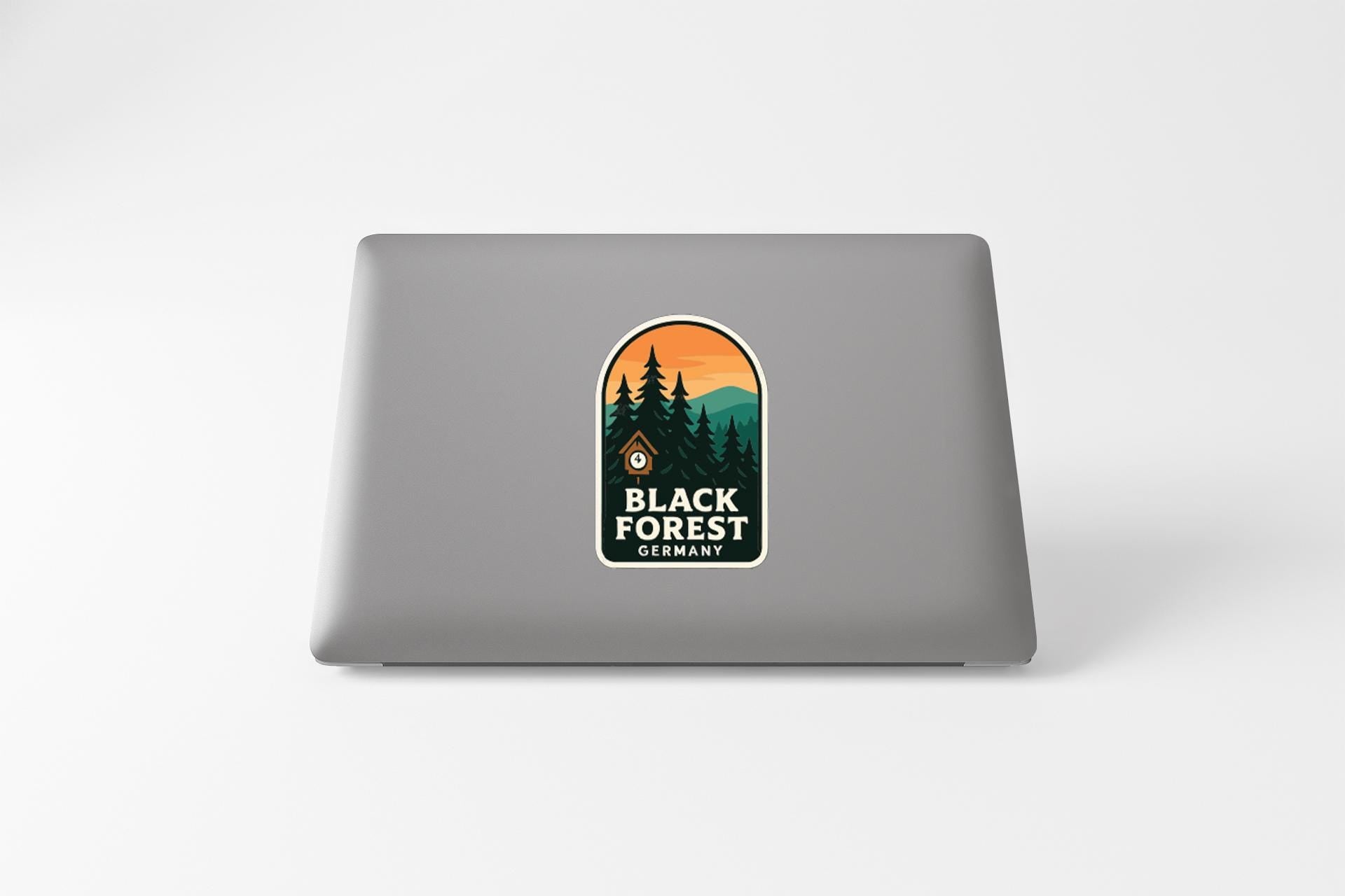 a sticker with a forest scene on a laptop.