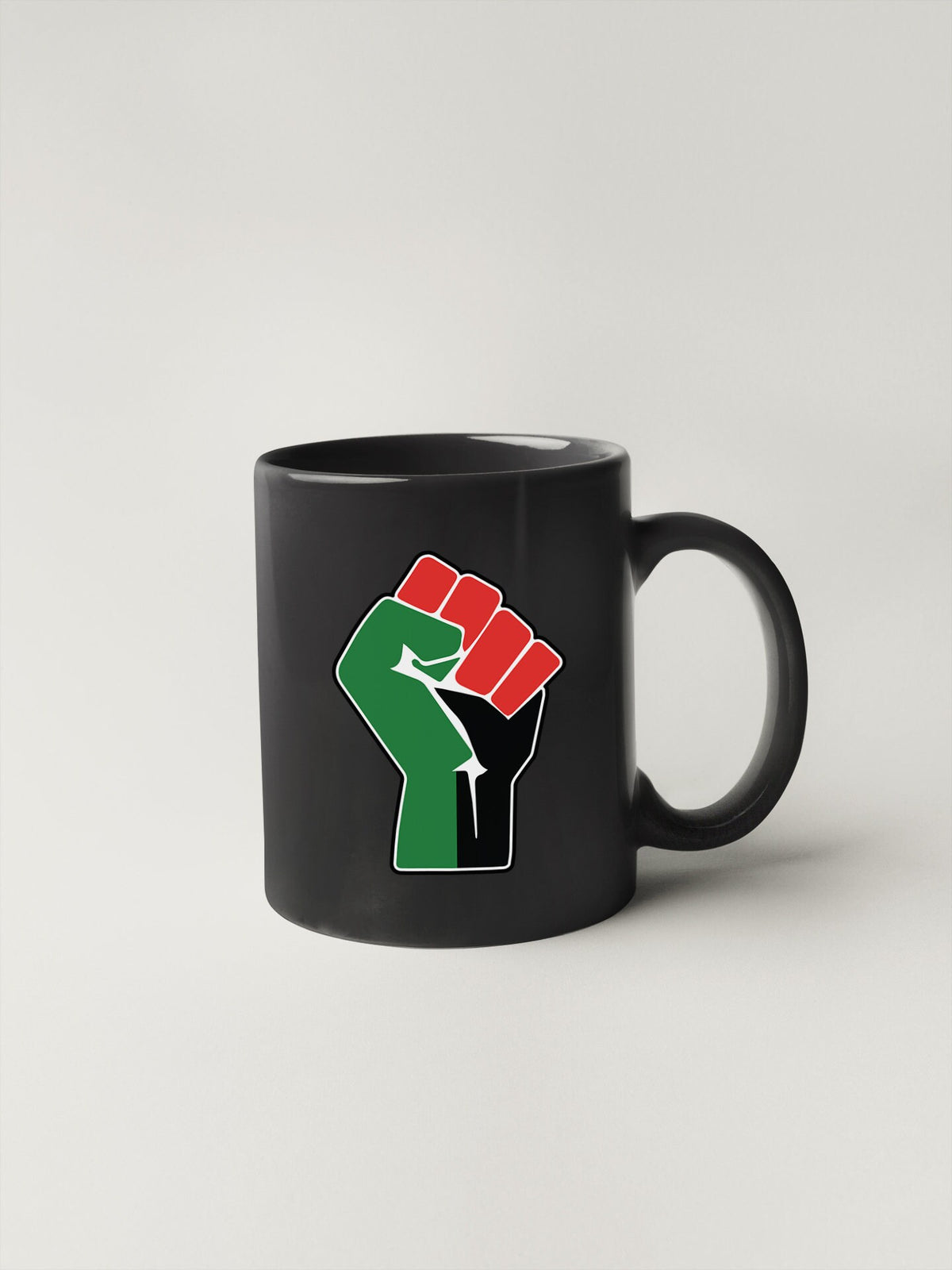 a black coffee mug with a green and red fist