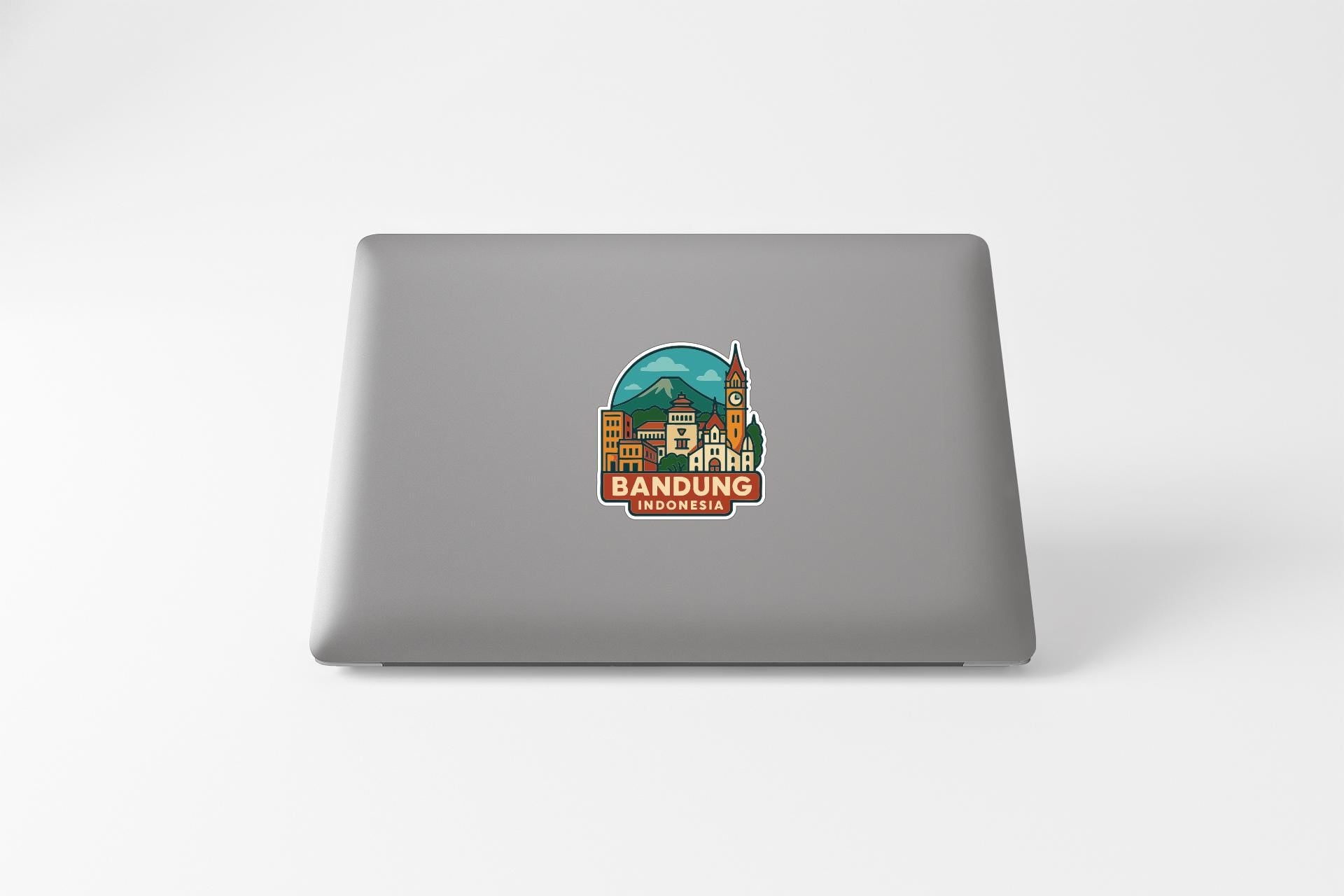 a sticker with a cityscape and the text "BANDUNG INDONESIA" on the back of a laptop.