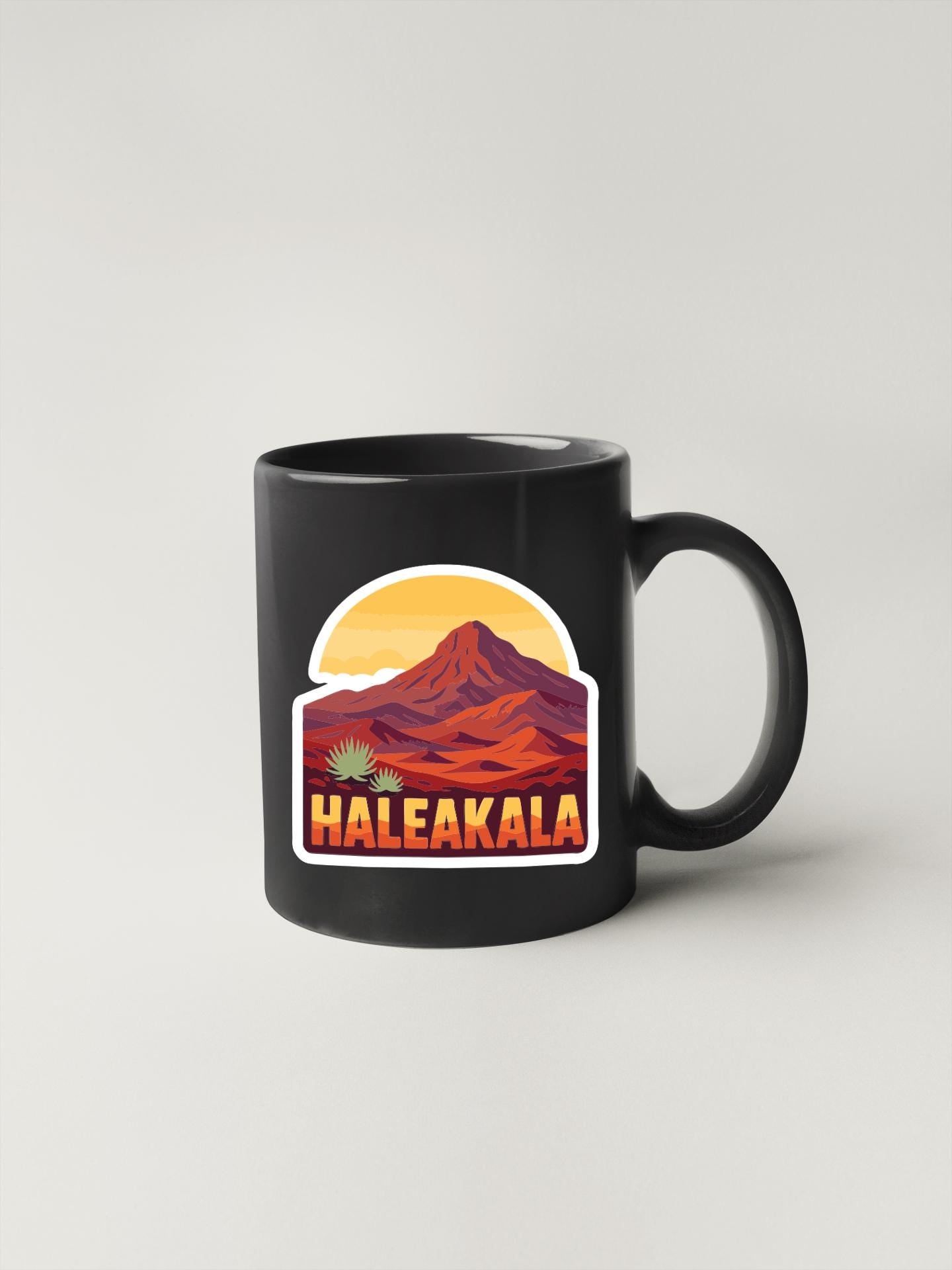 A black coffee mug with a graphic design depicting a mountain landscape and the word "Haleakala" written below it.